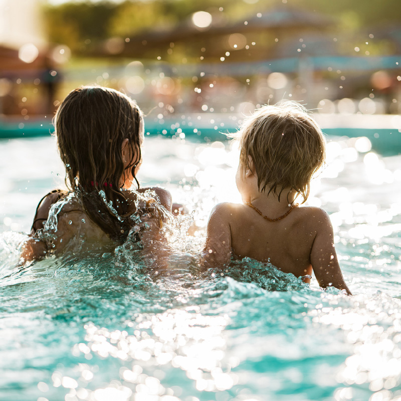 Two children splashing in pool